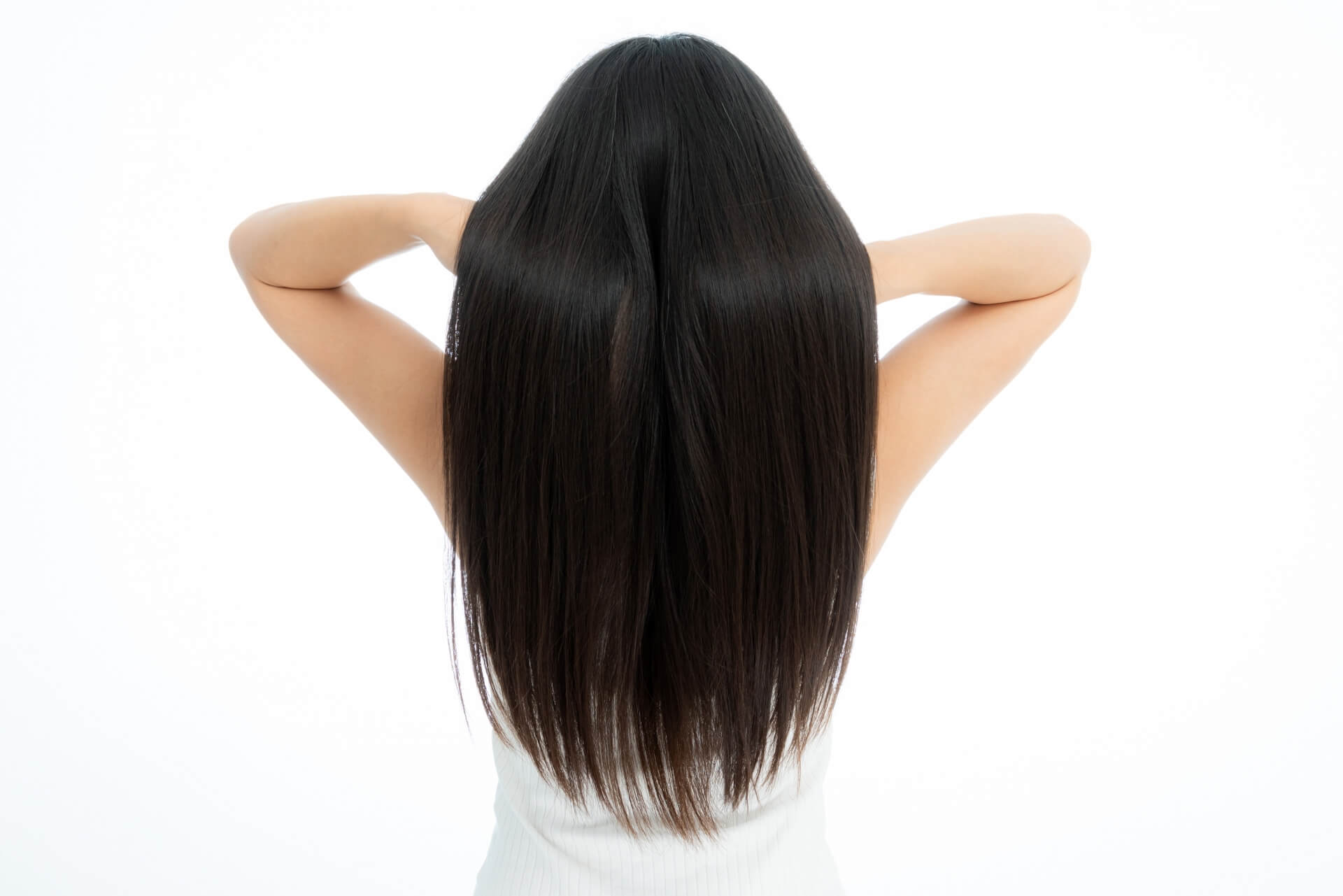 ツヤのある美しいストレートヘアを後ろ姿で見せる女性。正しいヘアケア習慣で健康的な髪を保つイメージ。