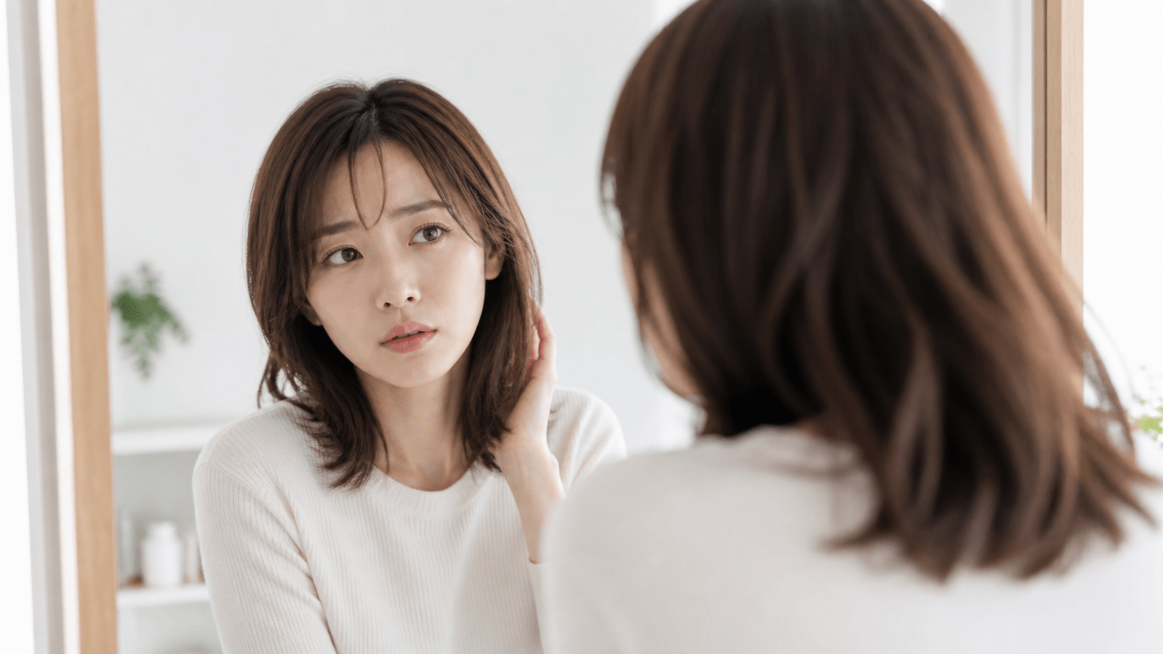 鏡の前で同じ髪型に飽きてしまった30代女性のイメージ