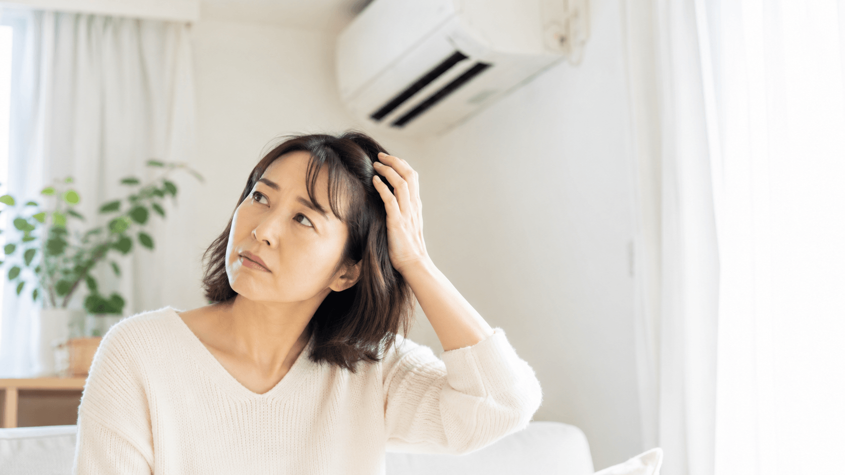 冷房 髪 乾燥 対策 エアコンの効いた部屋で髪を気にする女性