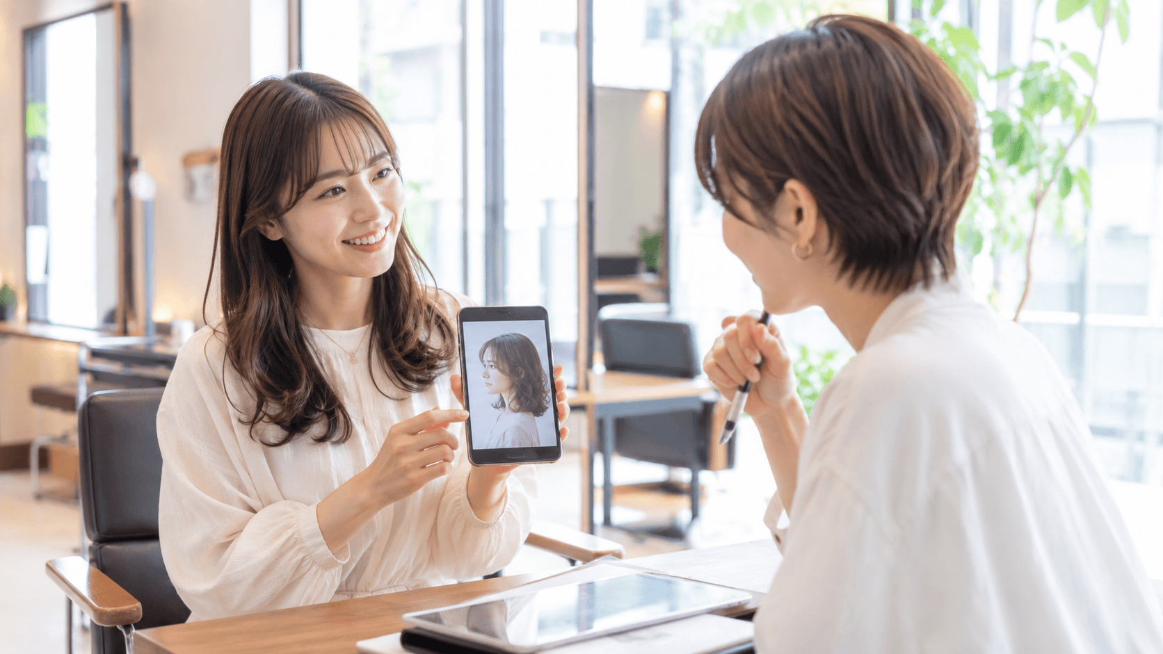 美容室で写真を見せながらカウンセリングを受ける30代女性
