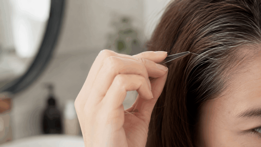 毛抜きでつい白髪を抜きそうになる女性の手元のクローズアップ