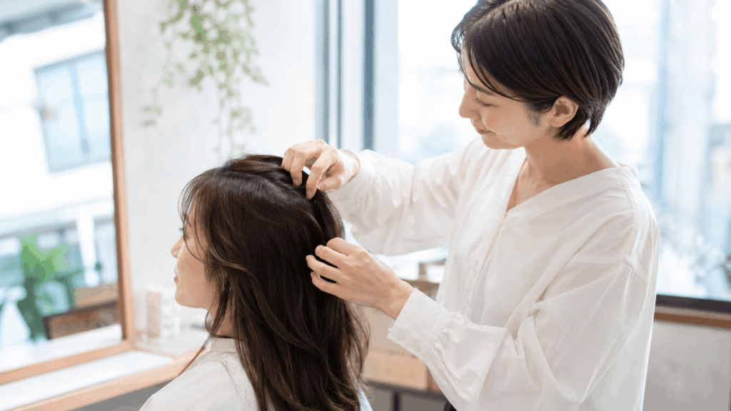 サロンで頭皮の状態をやさしく確認する女性の現場目線のシーン