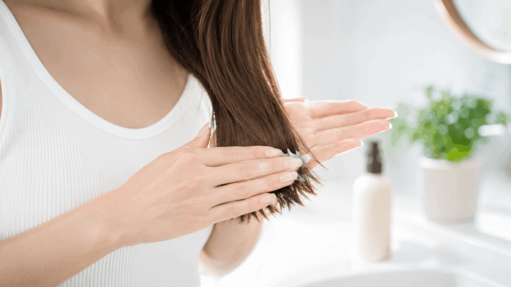 洗い流さないトリートメントを毛先になじませる女性の現場目線のシーン