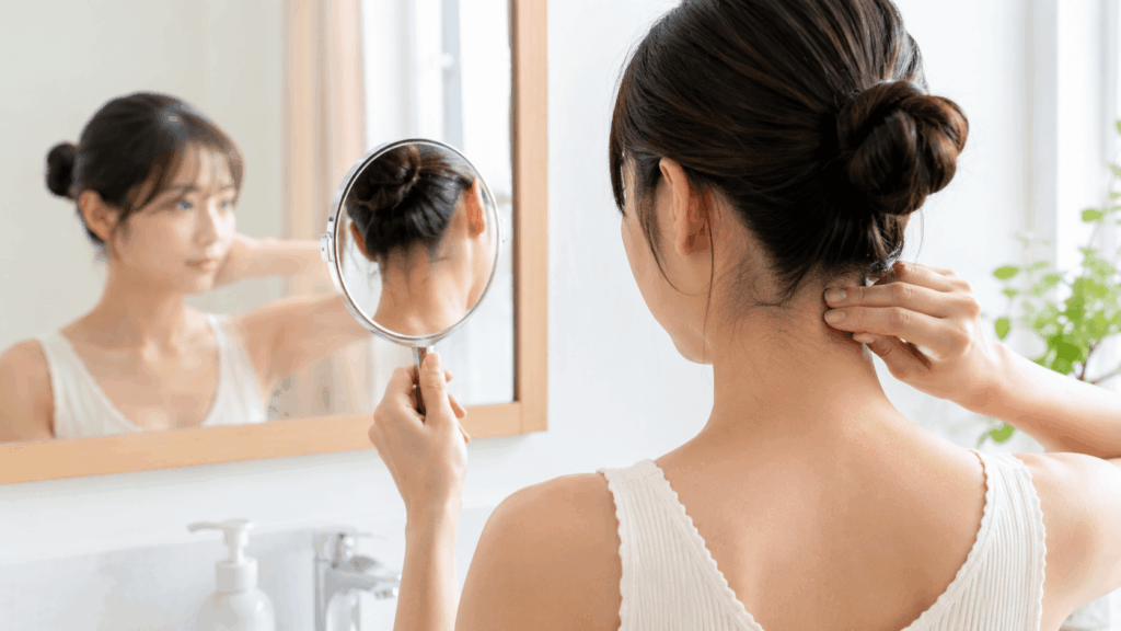 うなじセルフケアの注意点 鏡で確認しながらお手入れする女性