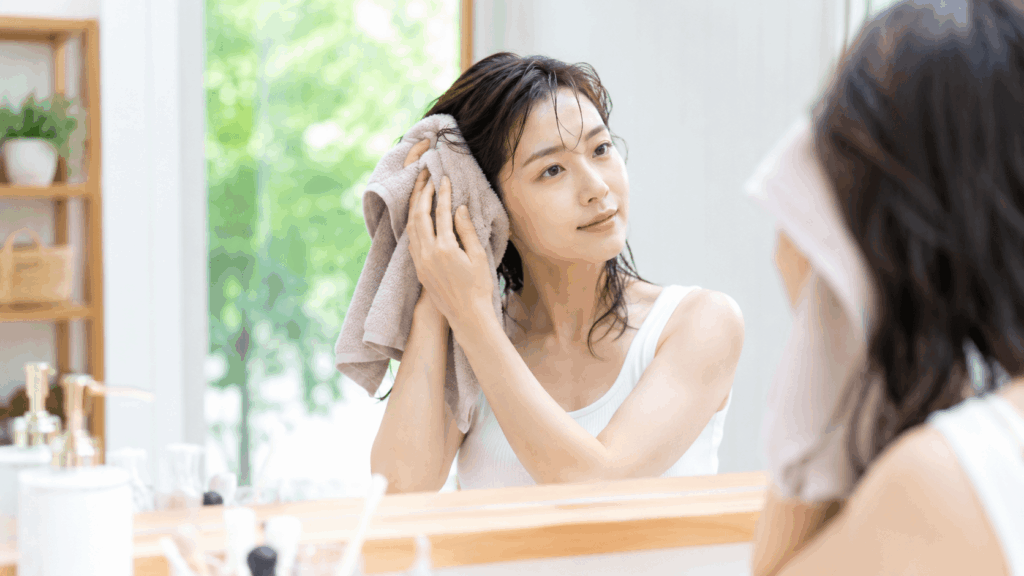 ヘアドライタオルで根元を押さえる女性